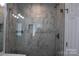 Updated shower with marble-look tile, sleek glass door, and a built-in shower caddy at 14621 Waterside Dr, Charlotte, NC 28278