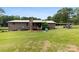 Backyard shot of the house with a green yard, deck, and covered parking at 1512 Mount Ulla Hwy, Mooresville, NC 28115