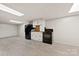 Basement kitchen with white cabinetry and a black oven and refrigerator at 1512 Mount Ulla Hwy, Mooresville, NC 28115
