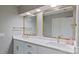 Modern bathroom featuring dual sinks, gold fixtures, large mirrors, and white cabinets at 15215 Arleta Cir, Charlotte, NC 28277
