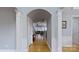 Open hallway featuring hardwood floors, decorative archway, and views into the living area at 15215 Arleta Cir, Charlotte, NC 28277