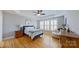 Serene main bedroom features a tray ceiling, hardwood floors, plantation shutters, and lots of natural light at 15215 Arleta Cir, Charlotte, NC 28277
