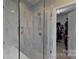 Elegant glass-enclosed shower with marble tile, a built-in niche, and a bench at 15215 Arleta Cir, Charlotte, NC 28277