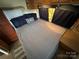 Comfortable RV bedroom featuring a comfortable bed, dark wood furnishings and storage at 164 Dogwood Cir, New London, NC 28127
