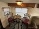RV dining area featuring a table with seating, overhead cabinets, and a cozy, functional design at 164 Dogwood Cir, New London, NC 28127