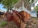 Exterior of trailer home with wooden steps leading to an entrance, complemented by lush greenery at 164 Dogwood Cir, New London, NC 28127