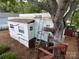 Exterior trailer view with ladder access, tree, and wooden deck, blending with the natural surroundings at 164 Dogwood Cir, New London, NC 28127