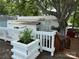 Exterior trailer view with ladder access, tree, and wooden deck, blending with the natural surroundings at 164 Dogwood Cir, New London, NC 28127