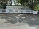 Exterior view of a trailer home with a white fence, set against a backdrop of trees and foliage at 164 Dogwood Cir, New London, NC 28127