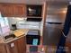 Functional RV kitchen featuring modern appliances, including a microwave, stove, sink, and refrigerator at 164 Dogwood Cir, New London, NC 28127
