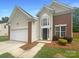 Two-story home featuring a brick and vinyl exterior, garage and manicured landscaping at 177 Jacobs Woods Cir, Troutman, NC 28166