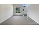 Empty living room features large windows providing natural light at 177 Jacobs Woods Cir, Troutman, NC 28166
