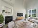 Bright living room featuring vaulted ceilings, a fireplace, and large windows at 177 Jacobs Woods Cir, Troutman, NC 28166