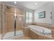 Bathroom showcasing a tiled shower and a relaxing soaking tub at 19143 Juanita Ln, Cornelius, NC 28031