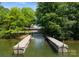 Picturesque boat ramp leading to a tranquil lake, framed by lush trees and serene natural beauty at 19143 Juanita Ln, Cornelius, NC 28031