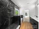 Modern bathroom features a marble tiled shower, wood floors, and a double sink vanity at 2006 St John St, Charlotte, NC 28216
