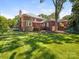 Large brick home with a well-maintained lawn and mature trees at 208 Huntley Pl, Charlotte, NC 28207