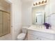 Clean bathroom features white tile, decorative mirror and glass enclosed shower at 208 Huntley Pl, Charlotte, NC 28207