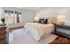 Comfortable bedroom with a large window, neutral colors and decorative throw pillows at 208 Huntley Pl, Charlotte, NC 28207