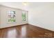 Bright bedroom with hardwood floors, white walls, and natural light from windows at 208 Huntley Pl, Charlotte, NC 28207