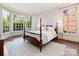 A light-filled bedroom features a four-poster bed with two side tables and a sitting area at 208 Huntley Pl, Charlotte, NC 28207