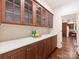 A beautiful butler's pantry has custom wood cabinetry with glass fronts and a light backsplash at 208 Huntley Pl, Charlotte, NC 28207
