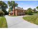 Well-manicured grounds surround this attractive brick home with a circular driveway and attached garage at 208 Huntley Pl, Charlotte, NC 28207