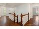 Upstairs hallway featuring hardwood floors and beautiful wood and white banister at 208 Huntley Pl, Charlotte, NC 28207