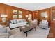 Cozy living room featuring wood paneling, built-in shelves, and comfortable seating at 208 Huntley Pl, Charlotte, NC 28207