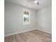 Sunlit bedroom features wood-look laminate flooring, a modern ceiling fan, and a large window at 2313 Ivey Church Rd, Maiden, NC 28650