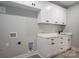 Bright laundry room featuring white cabinetry, sleek black hardware, and laminate flooring at 2313 Ivey Church Rd, Maiden, NC 28650