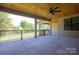 Covered patio with stained wood ceiling, ceiling fan and black railing overlooking lush landscaping at 2313 Ivey Church Rd, Maiden, NC 28650
