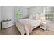 Cozy bedroom features a bed with white and pink linens, neutral walls, and natural light at 2315 Lawton Bluff Rd, Charlotte, NC 28226