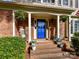 Inviting front porch featuring a bright blue door, rocking chairs, hanging plants, and brick steps at 2315 Lawton Bluff Rd, Charlotte, NC 28226