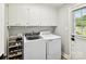 Laundry room features a washer, dryer, white cabinets and a window to the backyard at 2315 Lawton Bluff Rd, Charlotte, NC 28226