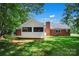 Brick house with covered back porch, chimney and lush green lawn at 2502 Gold Rush Dr, Lincolnton, NC 28092