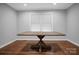 Sunlit dining area with hardwood floors showcasing a wooden table with a trestle base and bright windows at 2502 Gold Rush Dr, Lincolnton, NC 28092