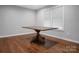 Bright dining area features hardwood floors, modern windows, and a unique wooden table with a distinctive trestle base at 2502 Gold Rush Dr, Lincolnton, NC 28092