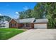 Classic brick home featuring a covered front porch, attached two car garage, and a spacious driveway at 2502 Gold Rush Dr, Lincolnton, NC 28092
