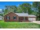 Charming brick ranch home featuring an attached garage, covered porch, and well-manicured front yard at 2502 Gold Rush Dr, Lincolnton, NC 28092