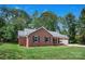 Charming brick ranch home with an attached garage, side porch with swing, and beautiful green lawn at 2502 Gold Rush Dr, Lincolnton, NC 28092