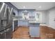 Modern kitchen with stainless steel appliances, blue cabinetry, granite counters, and durable hardwood floors at 2502 Gold Rush Dr, Lincolnton, NC 28092