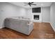 Inviting living room with hardwood floors, stylish gray sofa, and a fireplace with mounted TV at 2502 Gold Rush Dr, Lincolnton, NC 28092