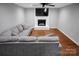 Cozy living room featuring hardwood floors, a white brick fireplace, and plush gray sectional sofa at 2502 Gold Rush Dr, Lincolnton, NC 28092