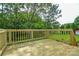 A wood deck overlooks a grassy backyard bordered with mature trees and a wooden fence at 2706 Lyla Ave, Concord, NC 28027