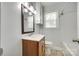 Cozy bathroom featuring a wooden vanity, wall storage, and a window above the toilet at 2833 Regency Rd, Lancaster, SC 29720