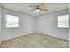 Neutral carpeted bedroom featuring dual windows and a ceiling fan at 2833 Regency Rd, Lancaster, SC 29720