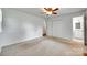 Neutral carpeted bedroom featuring ceiling fan, closet, and ensuite bathroom at 2833 Regency Rd, Lancaster, SC 29720