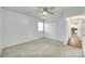 Well-lit bedroom with neutral carpet, ceiling fan and an entry to the home's kitchen at 2833 Regency Rd, Lancaster, SC 29720