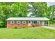 Charming brick home with a metal roof, tidy landscaping, and a covered carport at 2833 Regency Rd, Lancaster, SC 29720
